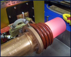 Photo shows copper tube annealing at the end of the heating stroke. Quench ring’s water spray is activated to prevent heat zone from moving beyond the required area.